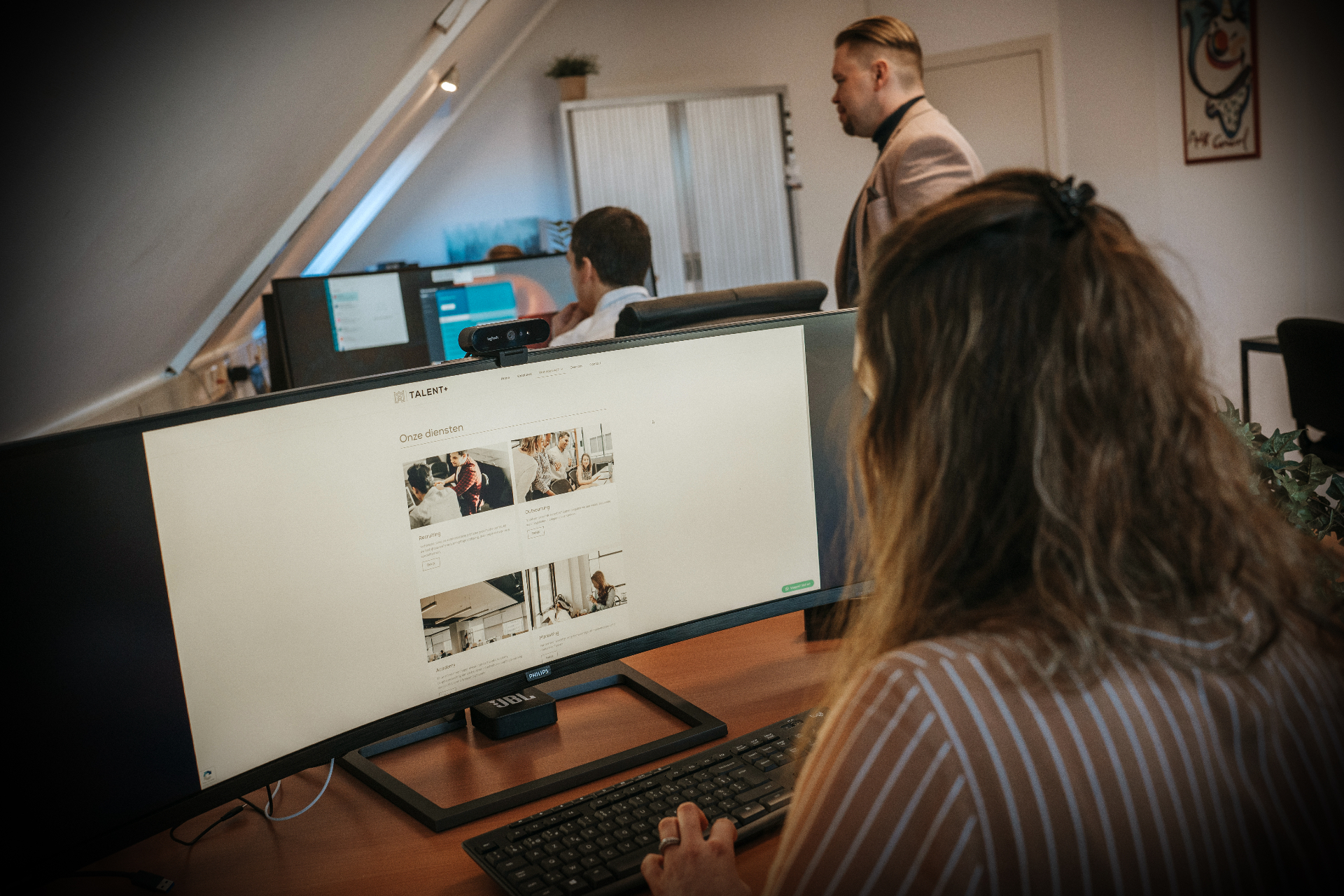 Talent+ team in kantooromgeving met het dienstenoverzicht op scherm